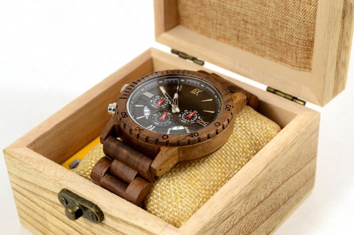 Luxury chronograph watch resting inside an open wooden watch safe